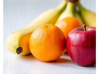 Assortment of common fresh fruits like oranges, apples, and bananas, ready for juicing.